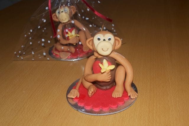 Two sugar monkeys with one wrapped in cellophane