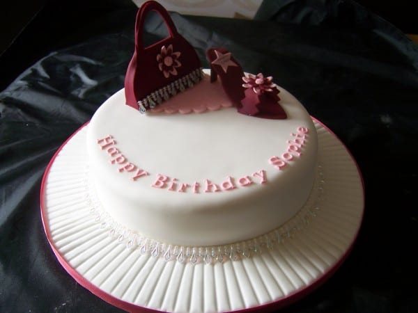 sugar handbag and shoe cake 1 tier white cake with maroon handbag and sugar shoe decorations on top