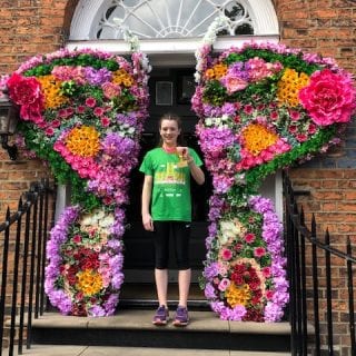 Violet with her 10k medal outside a floral door in Liverpool