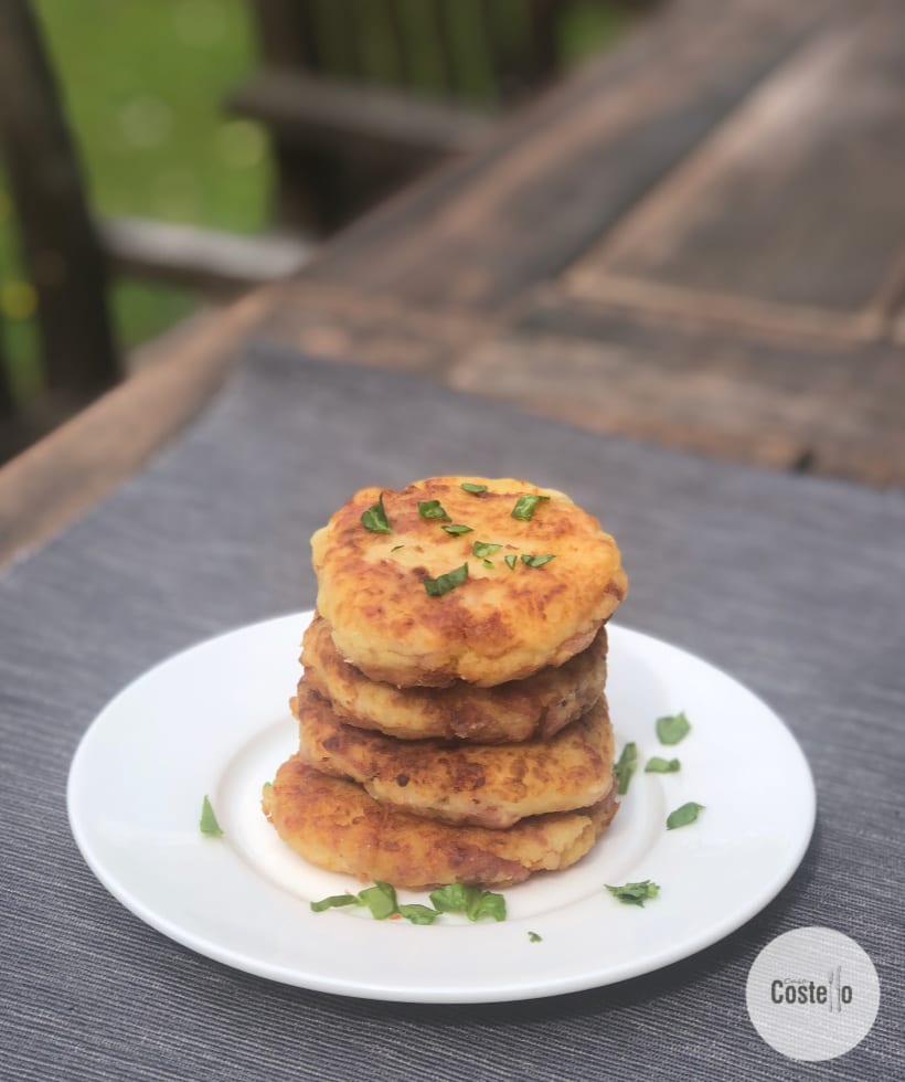Stack of Potato Cakes with Bacon pieces and Piri spice on a white plate