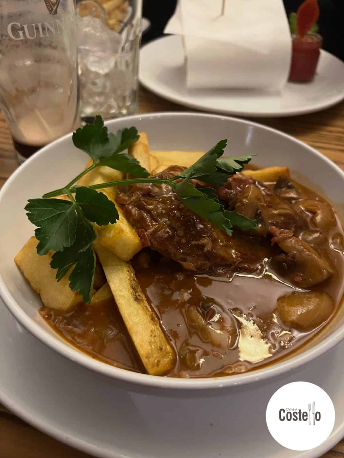 Bowl of beef stifado with chips and parsley