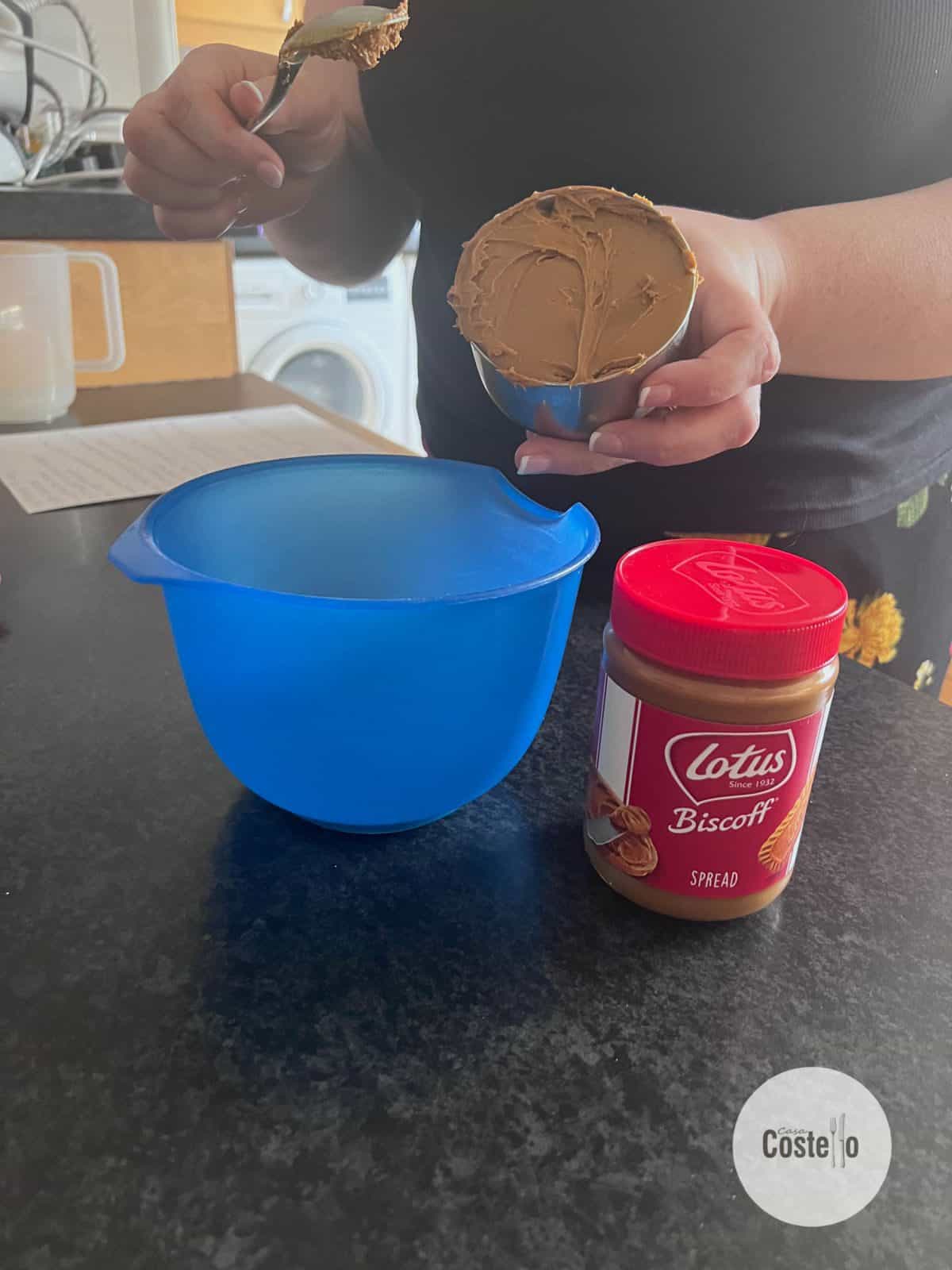 Biscoff spread in a cup measurement with a blue bowl