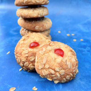 A stack of vanilla melting moments cookies with a cherry on top