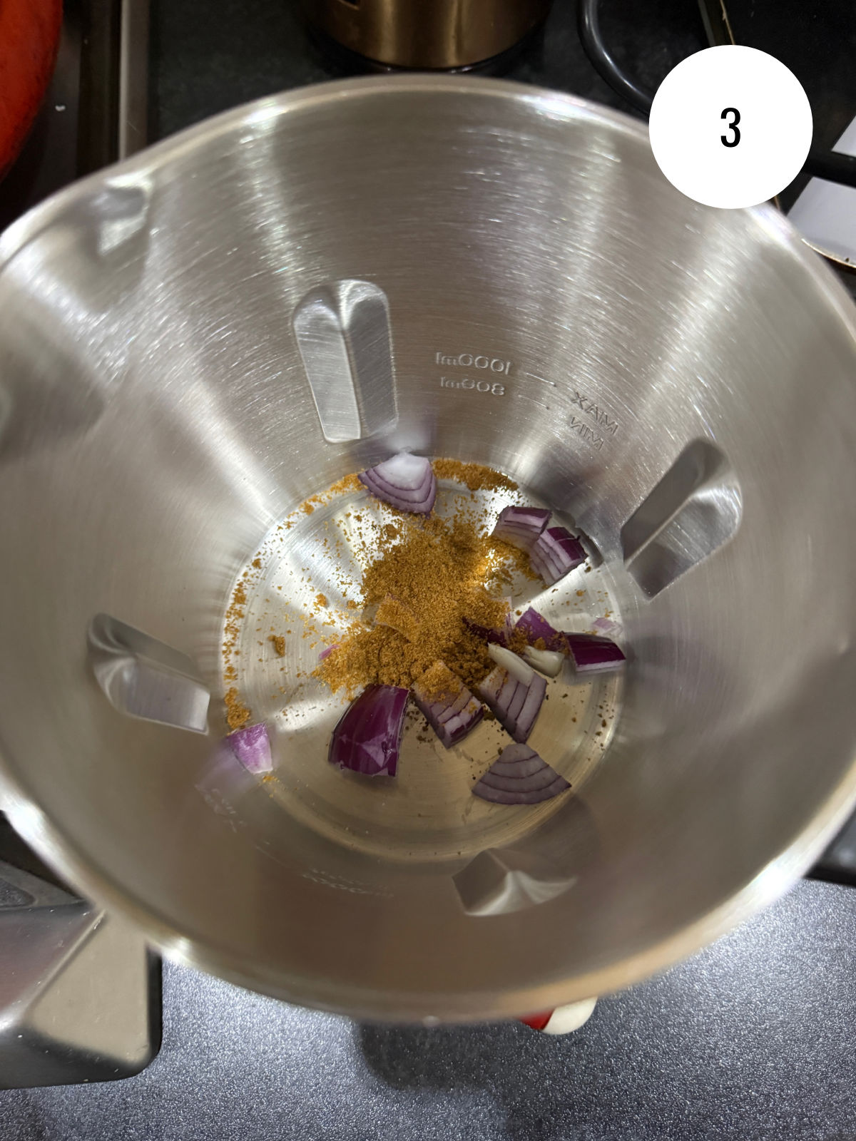 Adding vegetable stock and roughly chopped onions to a soup maker