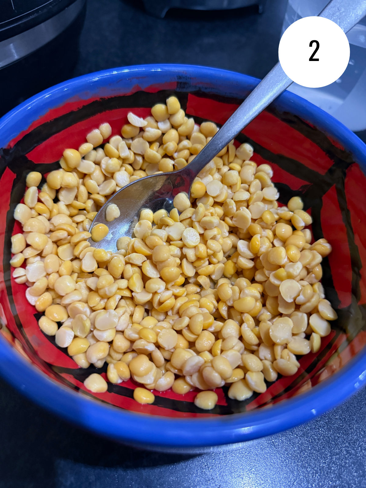 Yellow lentils that have been soaked in a small bowl ahead of cooking.